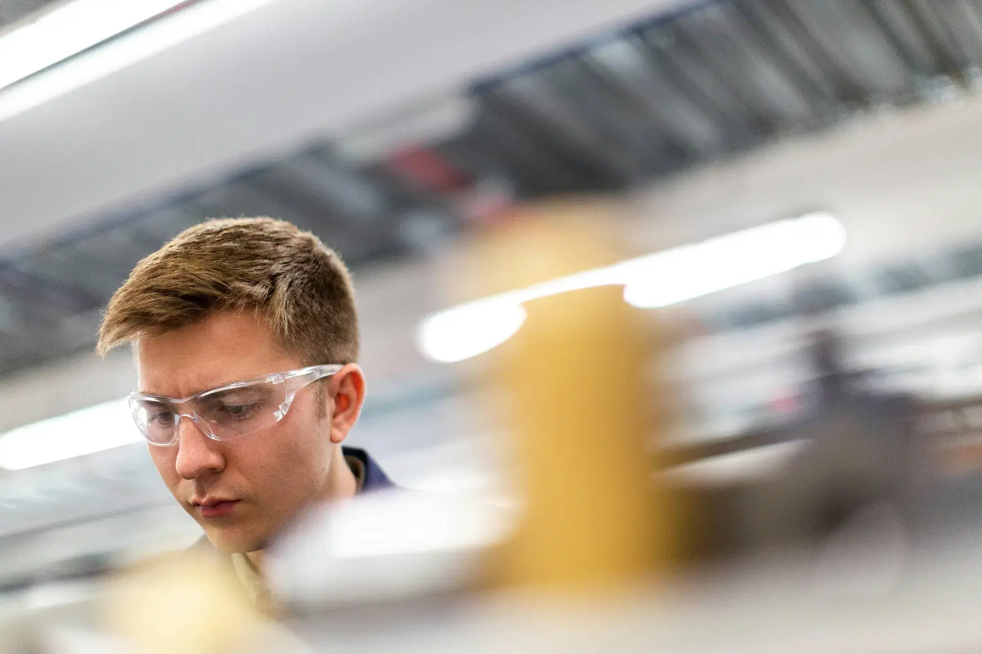 Mitarbeiter:in mit Schutzbrille in einer industriellen Umgebung
